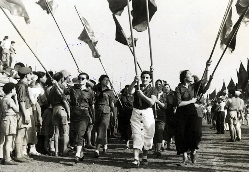 פועלות נושאות דגלי הלאום והמעמד בתהלוכת 1 במאי